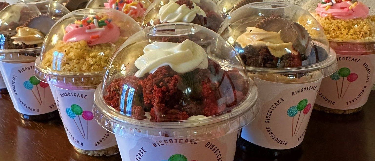 Layered cake in clear domed cups topped with frosting